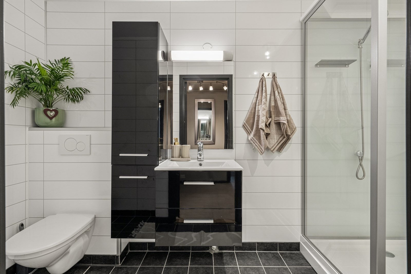 Baderommet er tidsriktig innredet med fliser på gulv og baderomsplater på veggene. Galleribilde