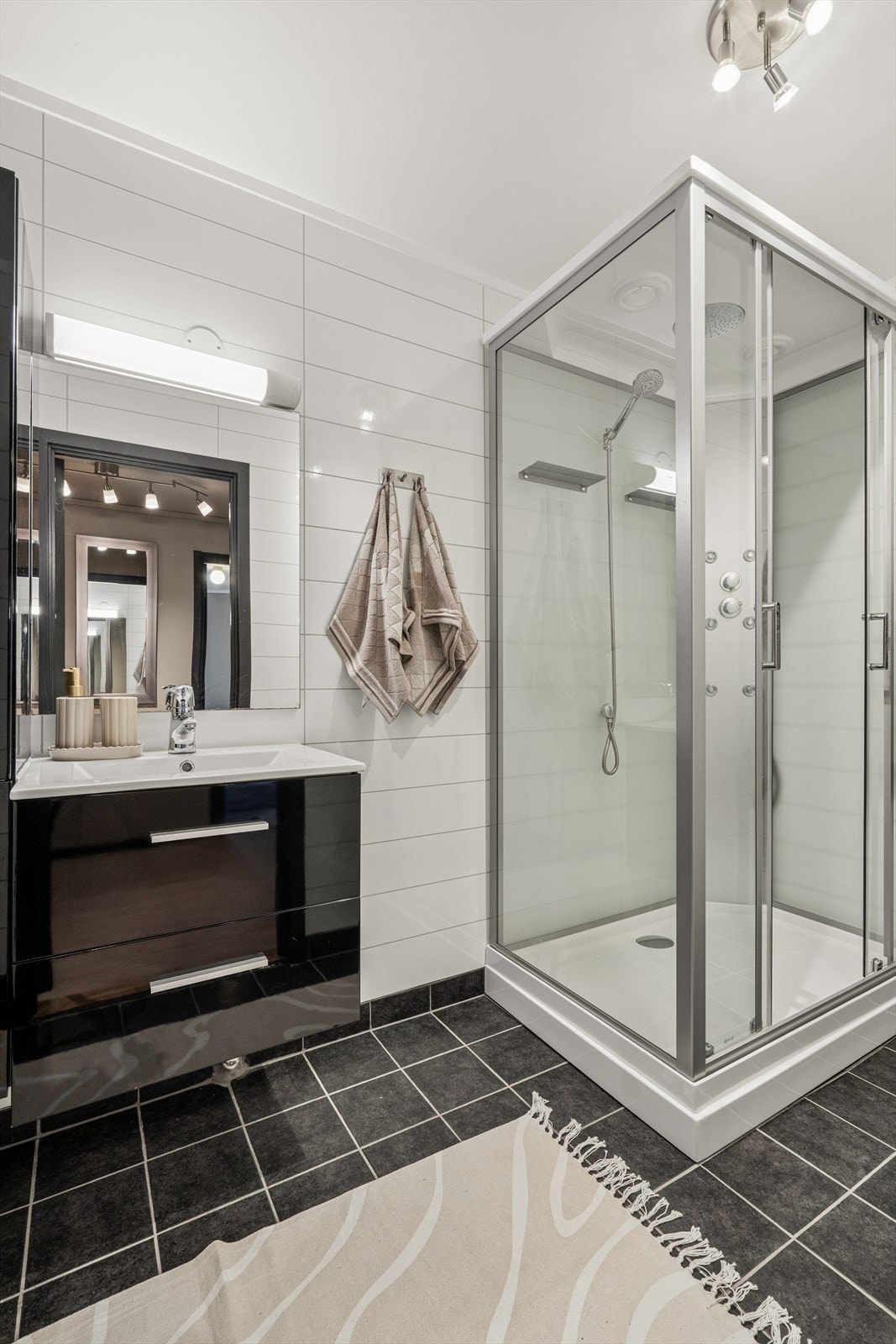 Baderommet er innredet med dusjkabinett og veggmontert toalett. Galleribilde