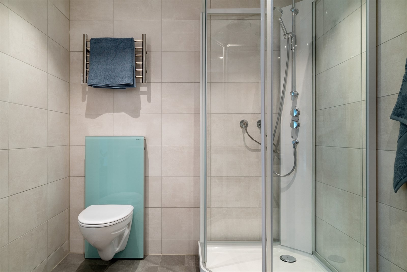 Badet er utstyrt med dusjhjørne, vegghengt toalett og servant. Galleribilde