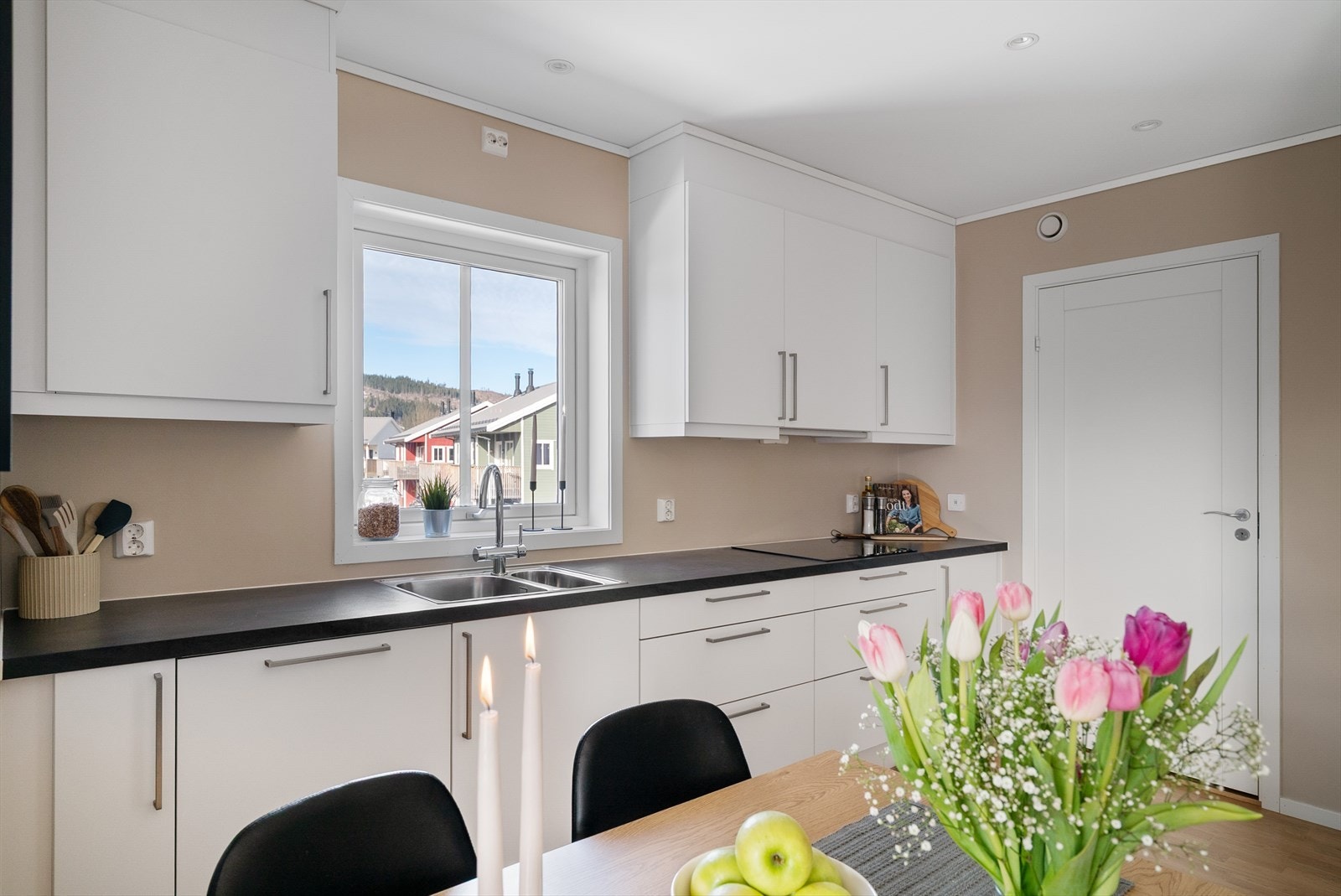 Pent og praktisk kjøkken med vindu over benkeplate som gir godt lysinnslipp. Galleribilde