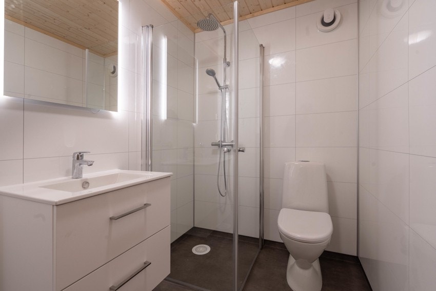 Bad dusjhjørne, vask med skuffer, speil med lyslist og wc. Galleribilde
