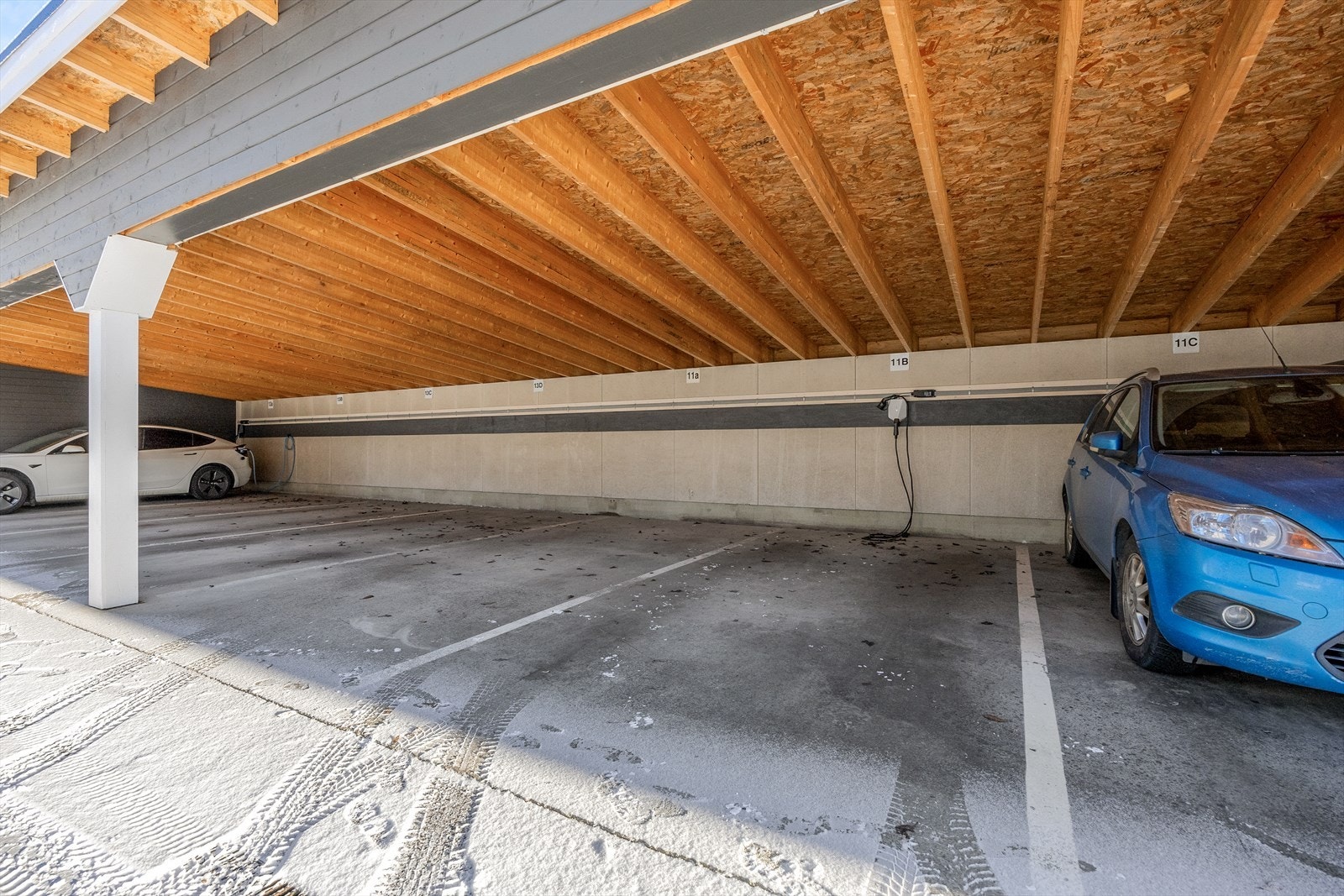 Det medfølger en parkeringsplass i åpen carport, med opplegg for elbillader. Galleribilde