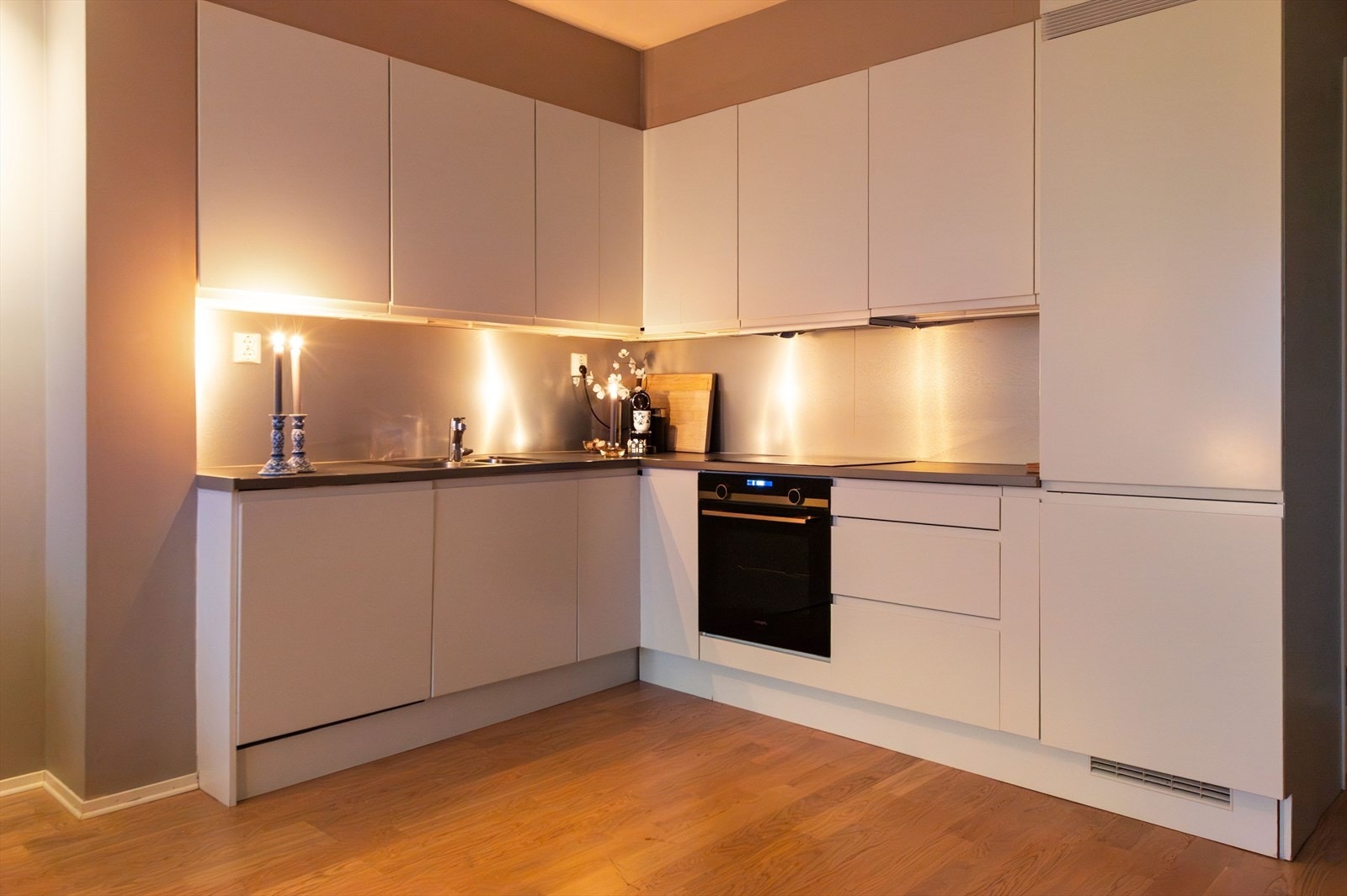 Moderne kjøkken med glatte fronter, benkeplate av laminat og integrerte hvitevarer. Galleribilde