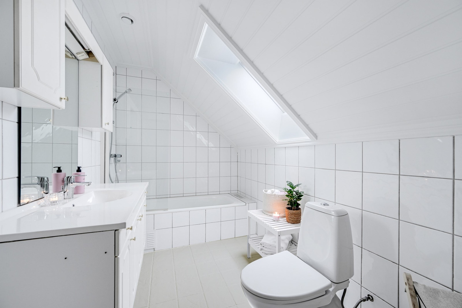 Flislagt bad med toalett, servant og badekar. Galleribilde