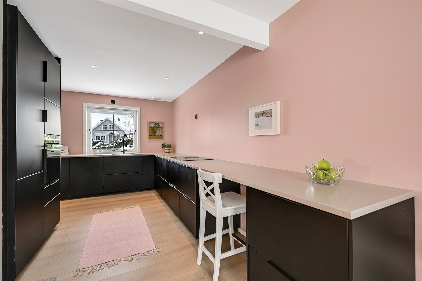 Stilrent kjøkken fra 2023 med innredning fra IKEA. Kjøkkenet har glatte fronter og en lekker benkeplate i stein/kompositt Galleribilde