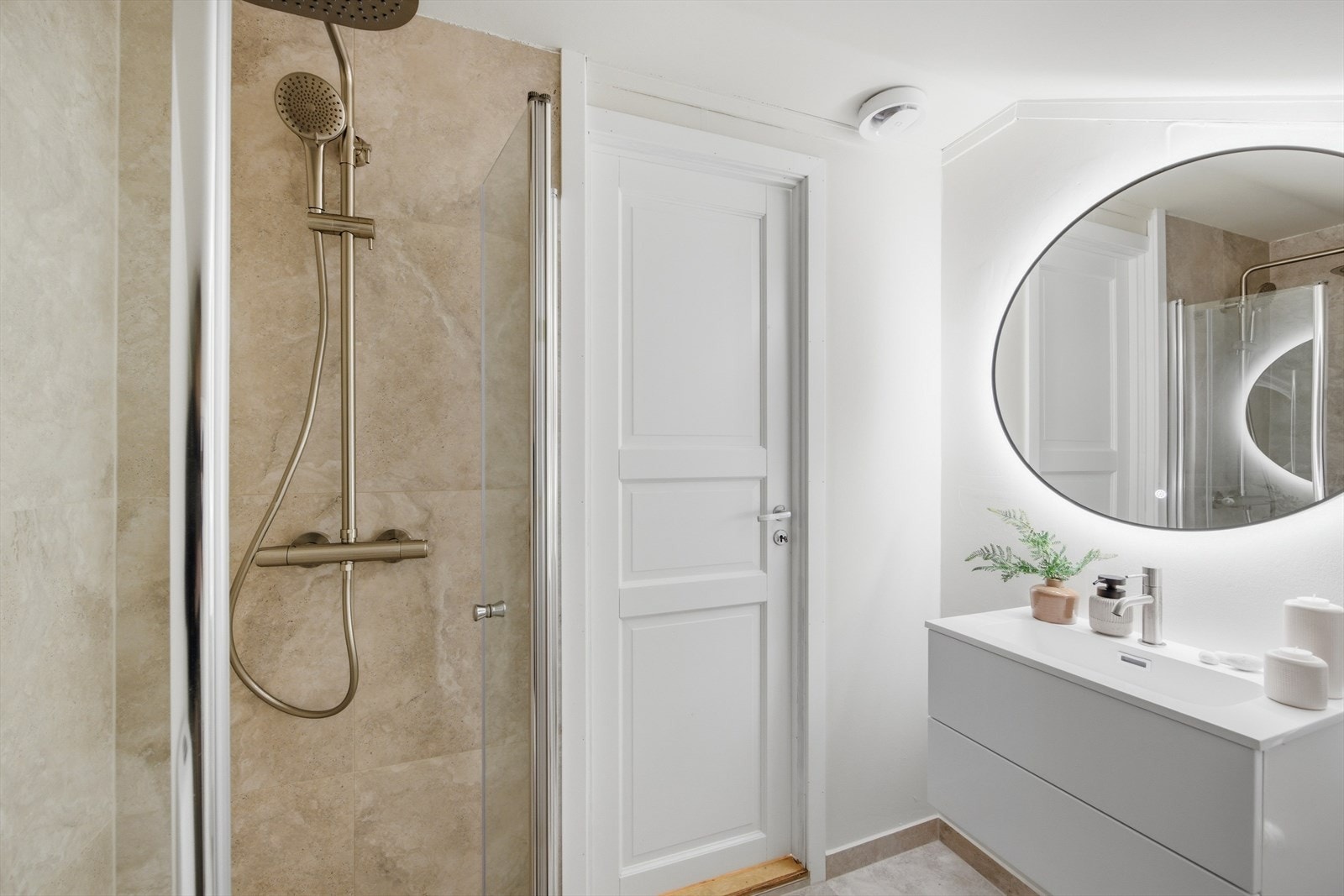 Leiligheten har et moderne bad med malte overflater, samt flis på gulv og i dusjsone Galleribilde