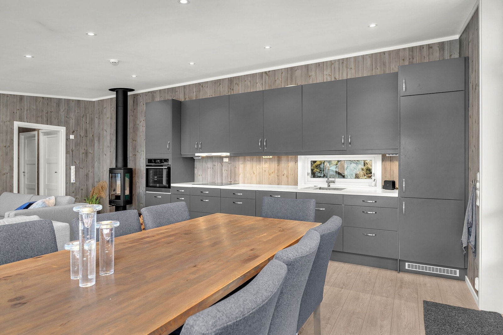 Moderne kjøkken med mørke, glatte fronter og en lys benkeplate Galleribilde