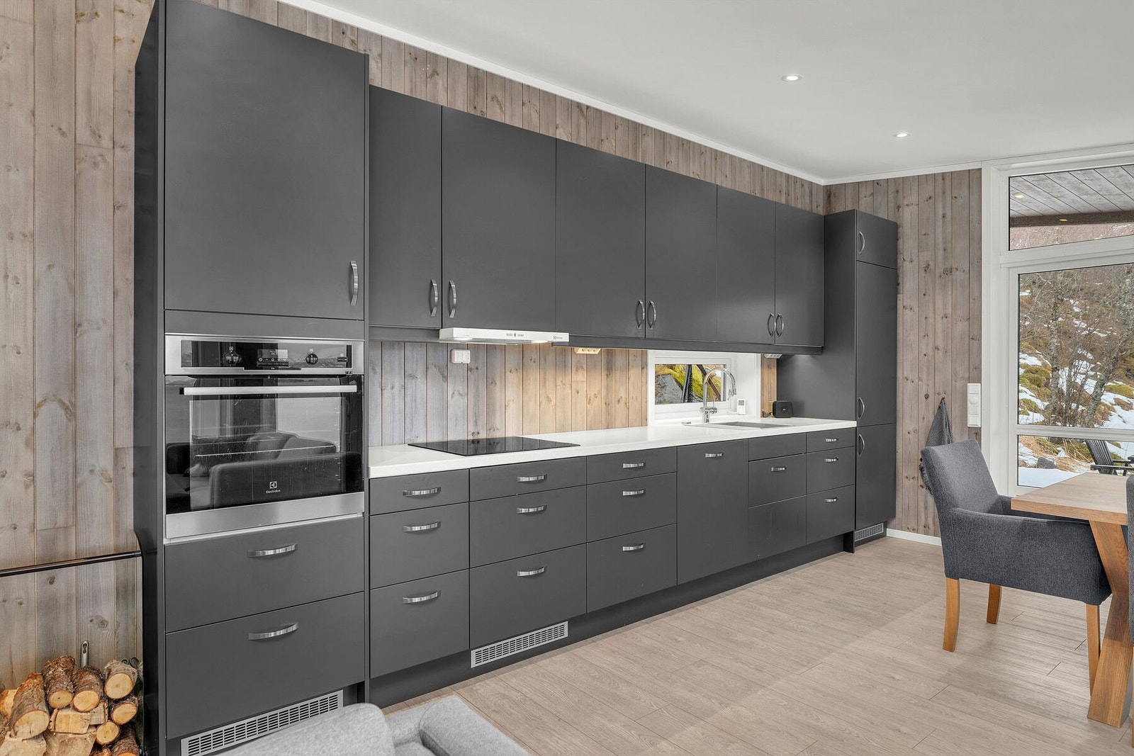 Kjøkkenet er utstyrt med integrerte hvitevarer, herunder stekeovn, platetopp, ventilator, oppvaskmaskin og kjøl/frys Galleribilde