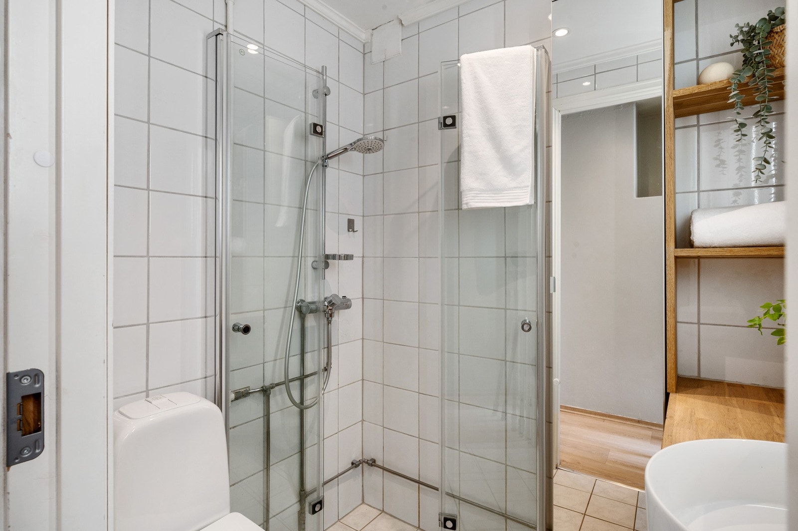 Pent og lyst bad på 2,2 m². Badet er helfliset, og har varmekabler i gulvet. Baderomsinnredningen består av toalett, helstøpt servant, og dusjdører i klart glass. Galleribilde