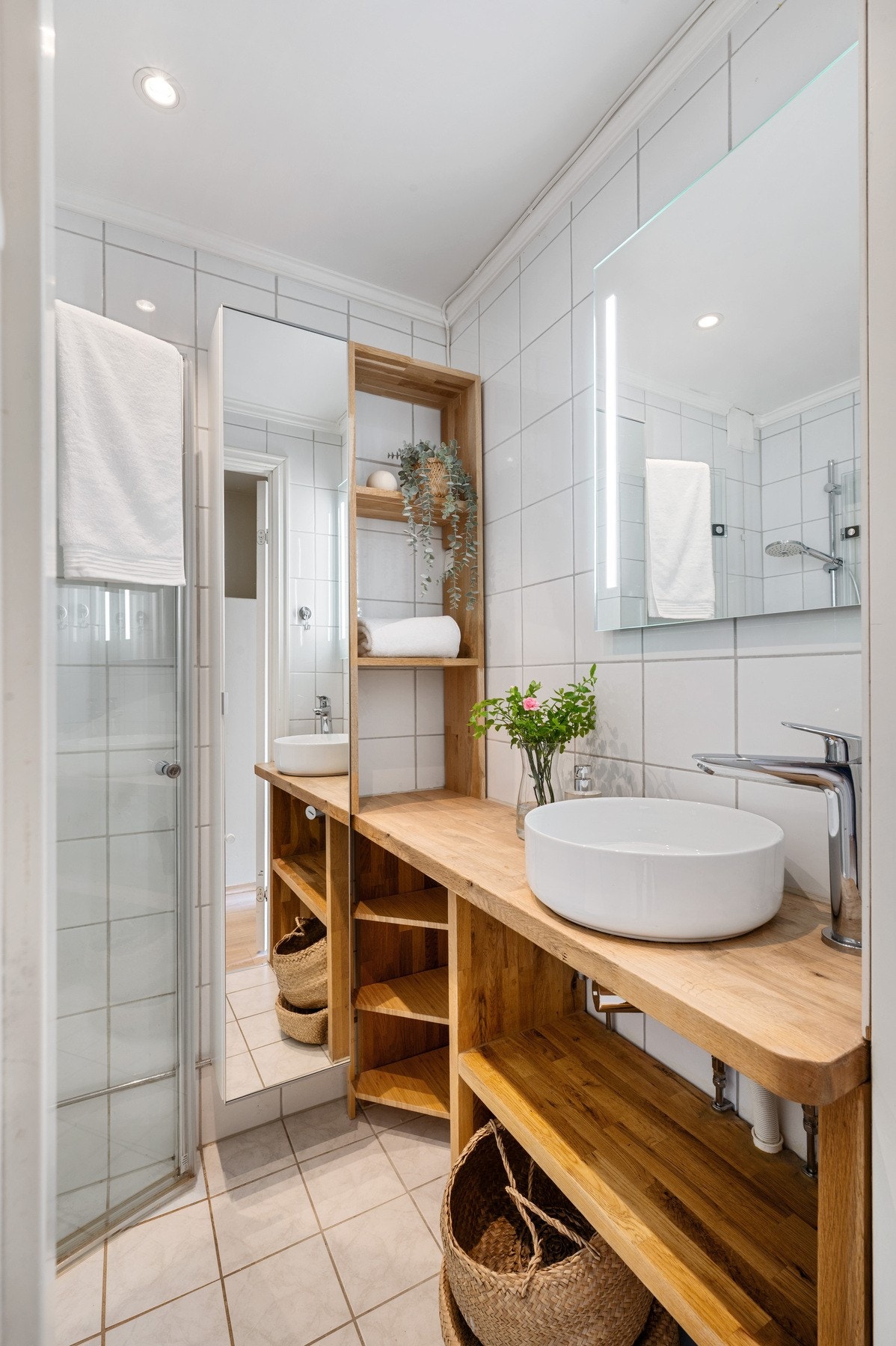 Innredet med toalett, speil med integrert belysning og dusjhjørne. Galleribilde