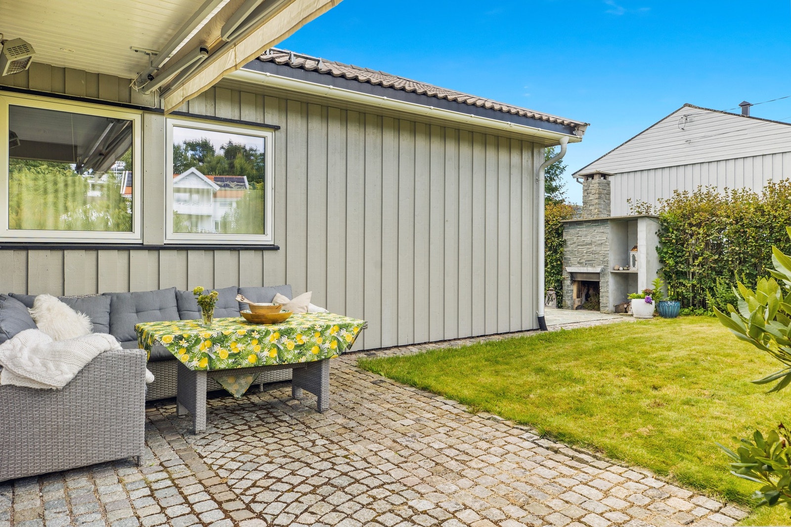 Eiendommen har flere hyggelige uteområder. Her på vestsiden er det montert elektrisk markise og terrassevarmer. Galleribilde