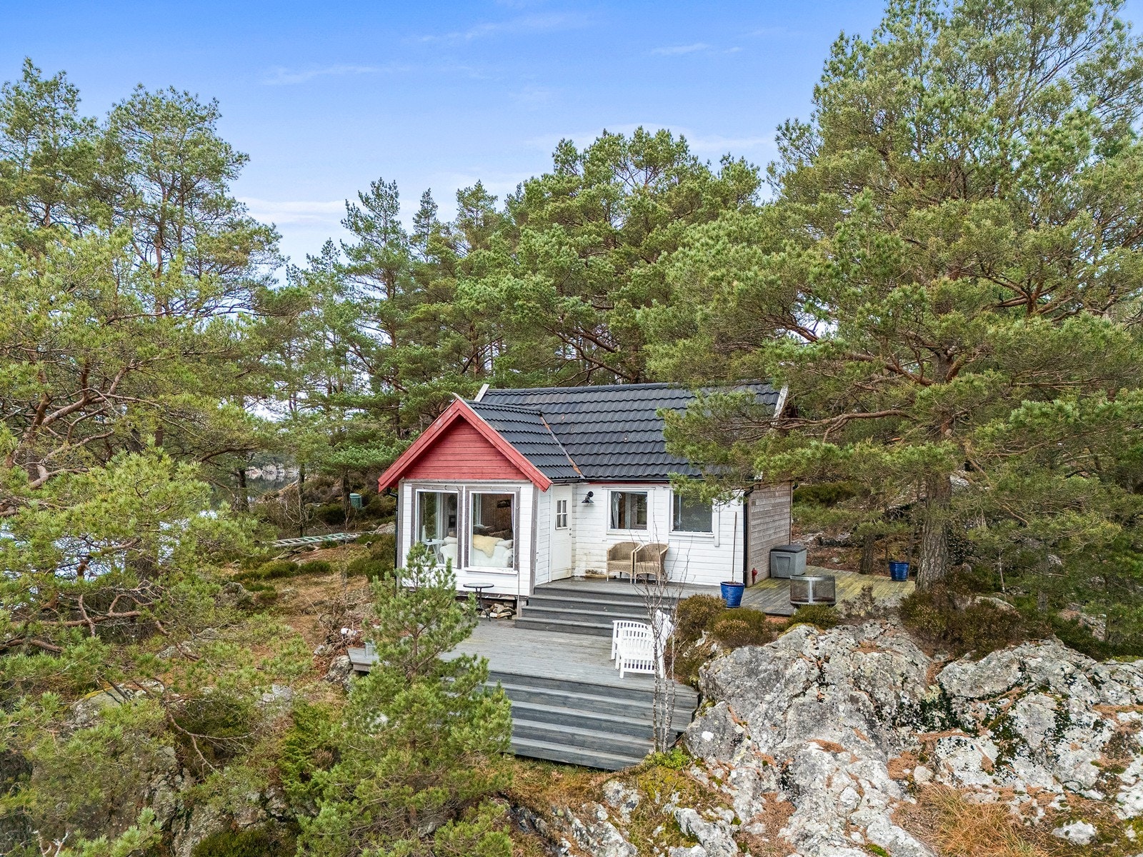 Hytta ligger idyllisk til ytterst på en nes omgitt av furuskog og sjø. Galleribilde