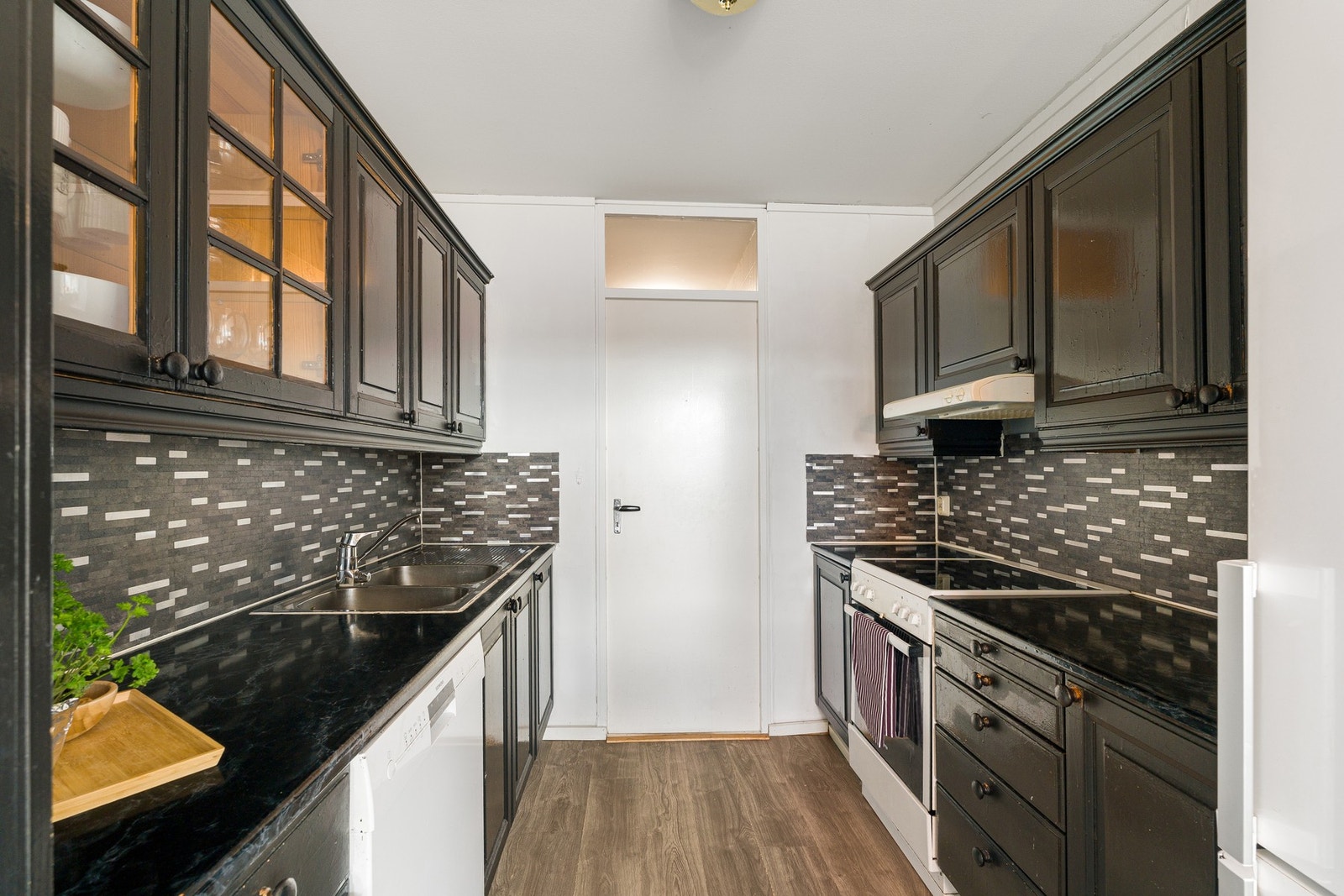 Praktisk og funksjonelt kjøkken med gode arbeidsflater og fliser på veggene for enkel vask. Galleribilde