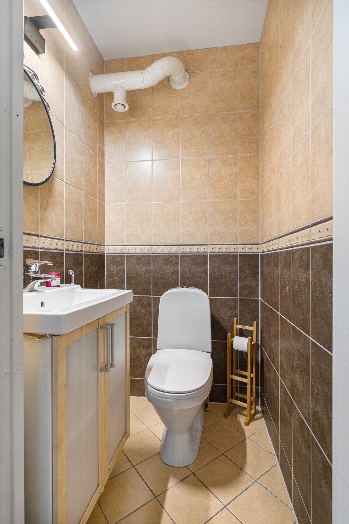 Pent toalettrom med fliser i rolige fargetoner. Galleribilde