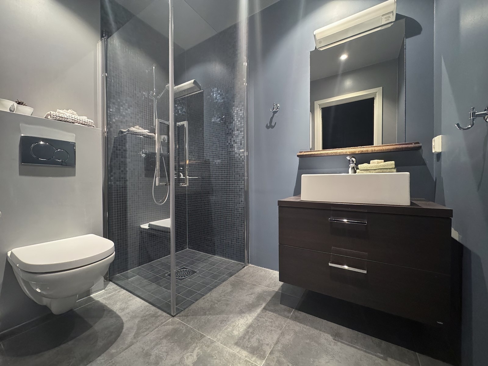 Det er innredet med vegghengt toalett, baderomsmøbel med praktiske skuffer og en nedfelt servant som gir god oppbevaringsplass og en ryddig overflate Galleribilde