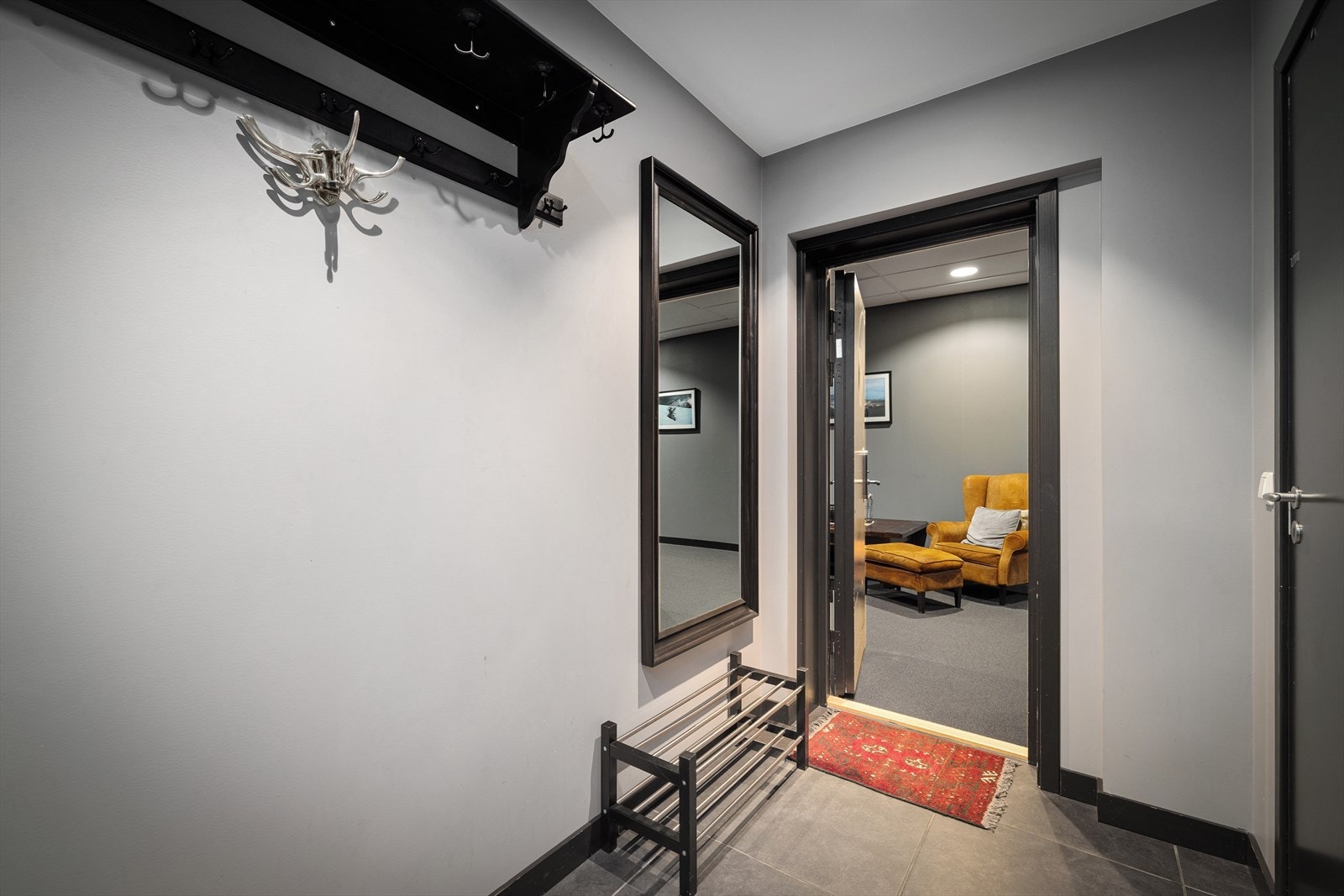 Velkommen inn i leiligheten. Entréen møter deg med et stilrent uttrykk som setter tonen for resten av boligen. Galleribilde