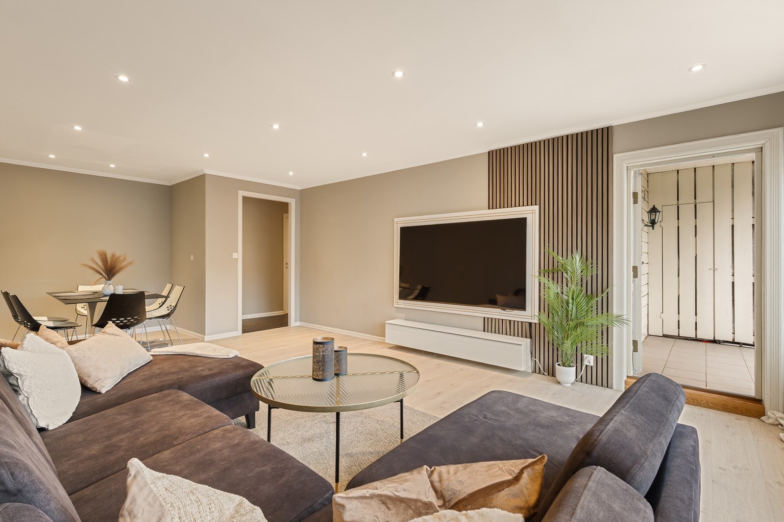 En stor og romslig stue som gir et luftig inntrykk og har god plass til både sofa, TV-benk og spisebord Galleribilde