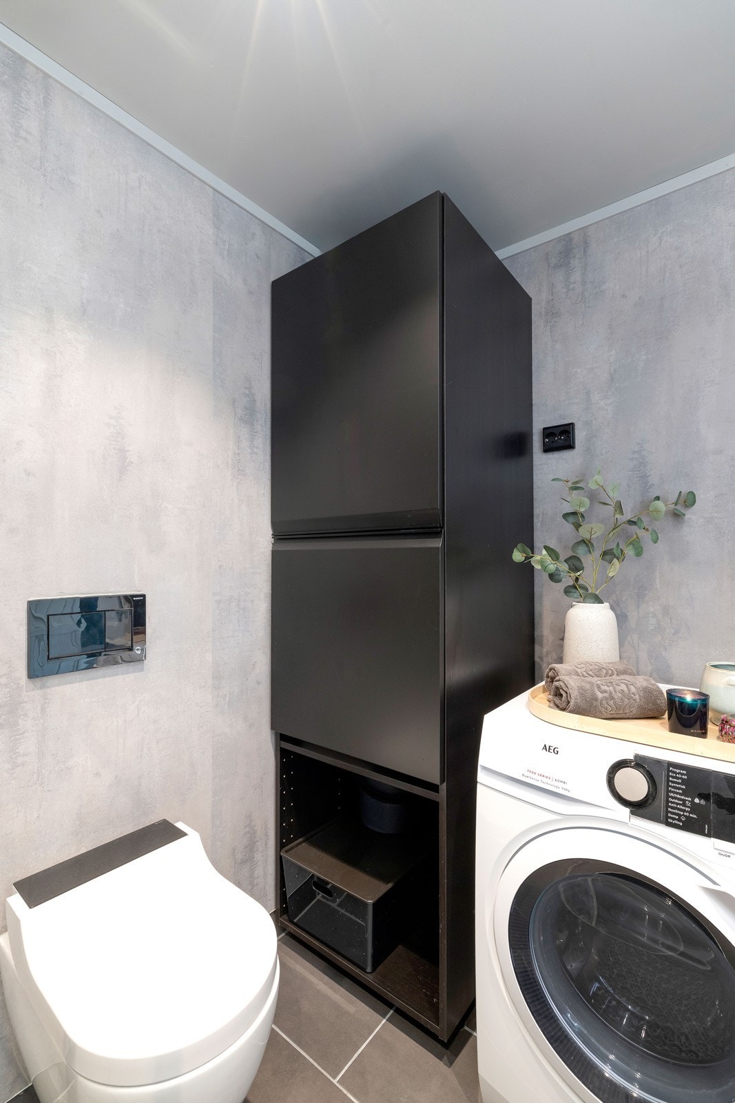 Badet har dusjhjørne, vegghengt spyle toalett og servant med underskuffer. Opplegg til vaskemaskin. Galleribilde