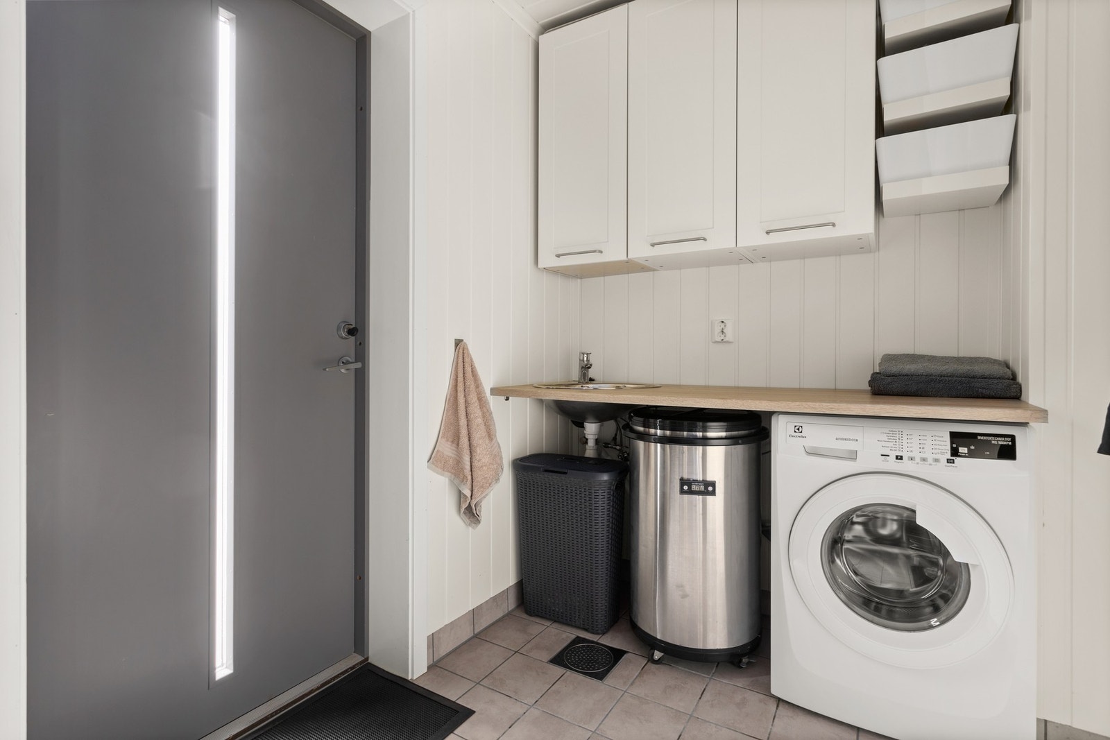 Vaskerom - ca 4,5 kvm. Innredning med skap og benkeplate med vask, samt opplegg for vaskemaskin. Dør ut til terrasse Galleribilde