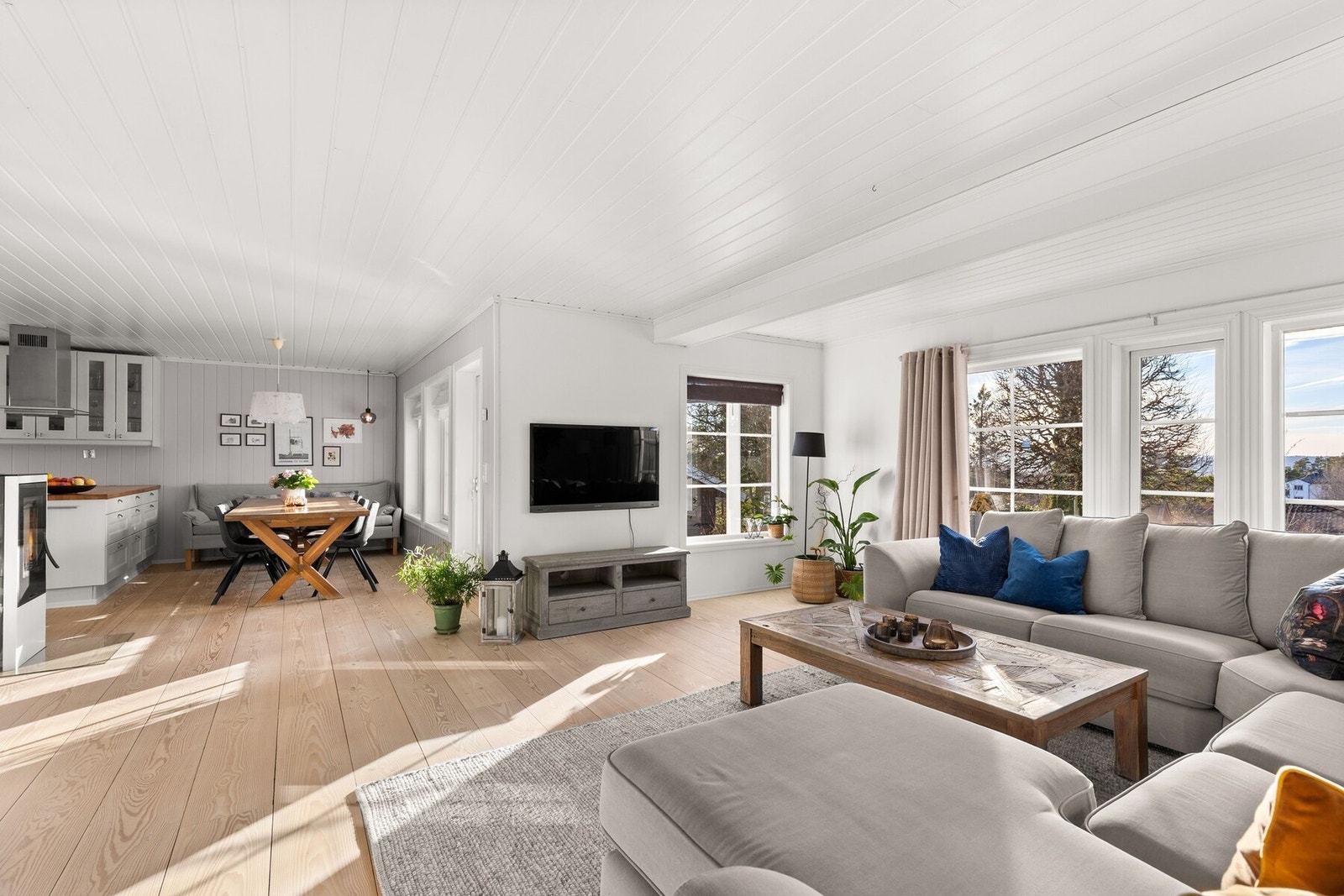 Den åpne løsningen mot kjøkkenet skaper en moderne og inkluderende romfølelse, perfekt for både hverdagsliv og sosiale sammenkomster. Galleribilde
