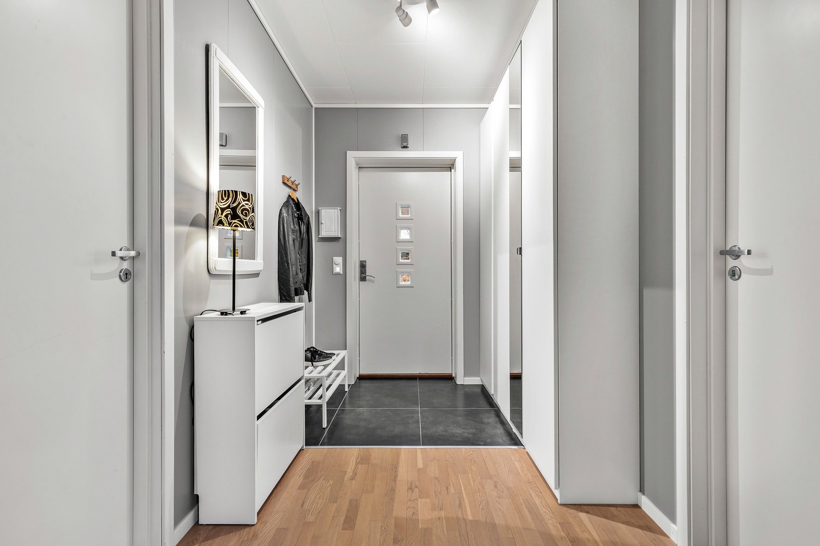 Entréen er delvis flislagt med mørke 60x60 fliser og god plass til garderobeskap Galleribilde