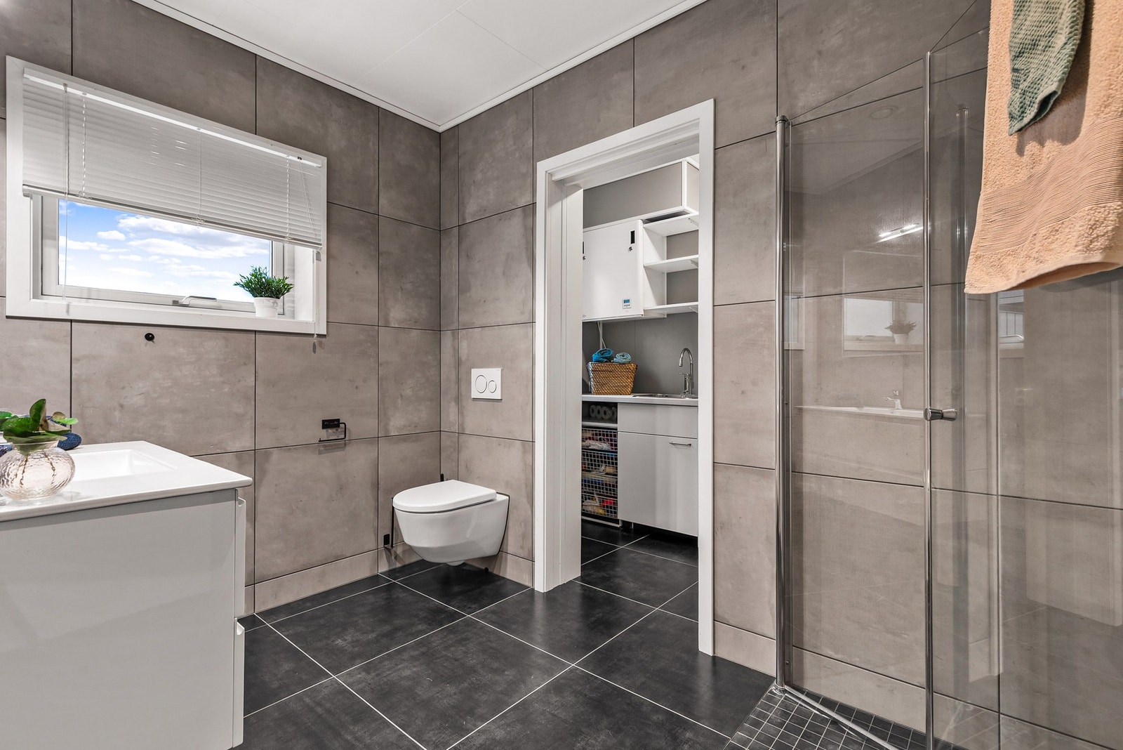 Helfliset bad med 60x60 fliser, gulvvarme og nedsenket himling med innfelte downlights Galleribilde