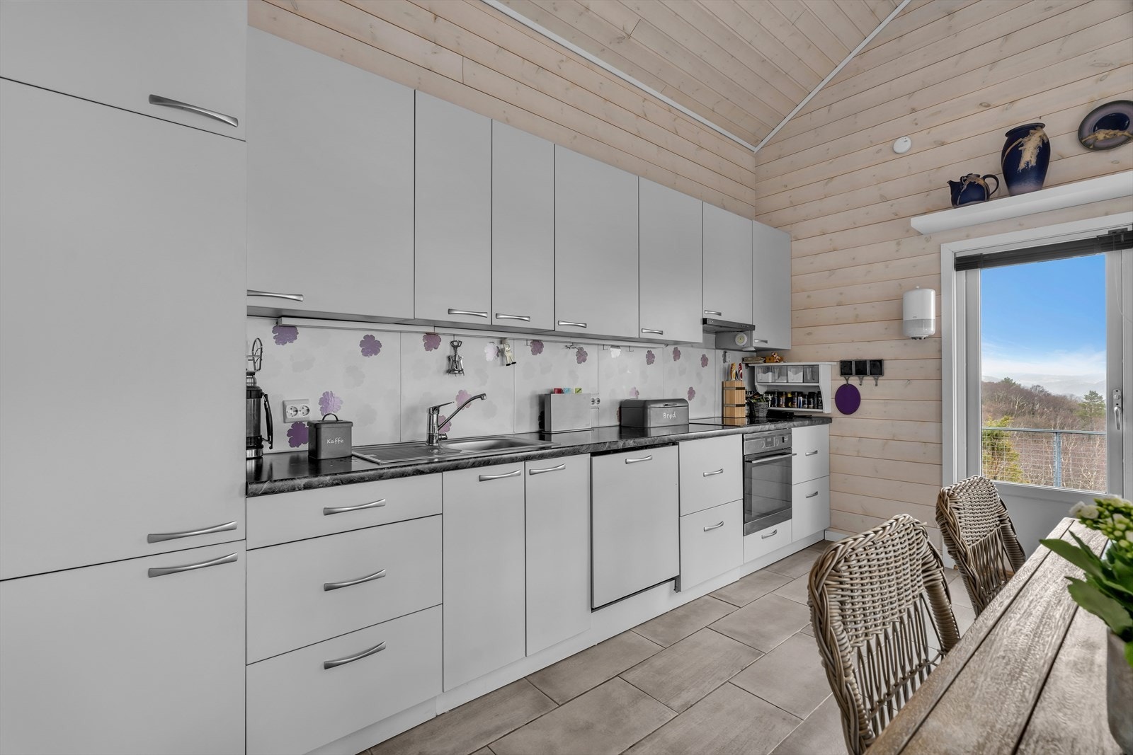 Kjøkkeninnredning med glatte fronter og benkeplate av laminat. Galleribilde