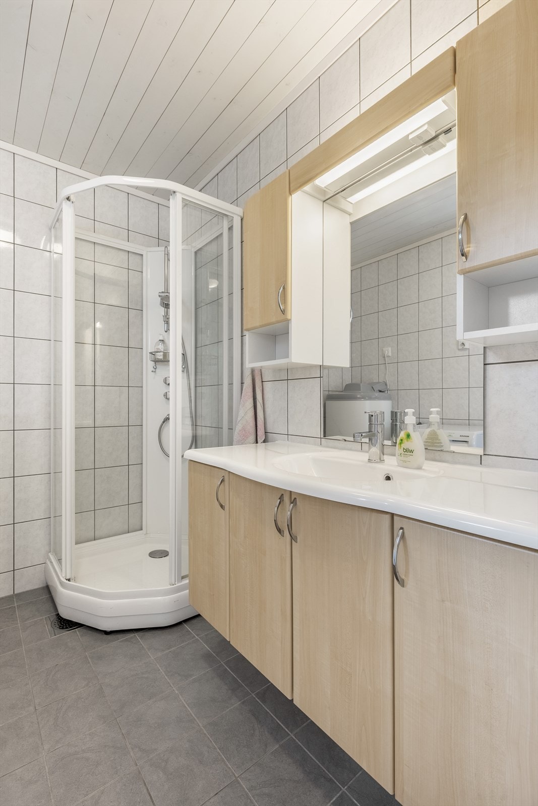 Badet er innredet med servant, dusjkabinett og toalett Galleribilde