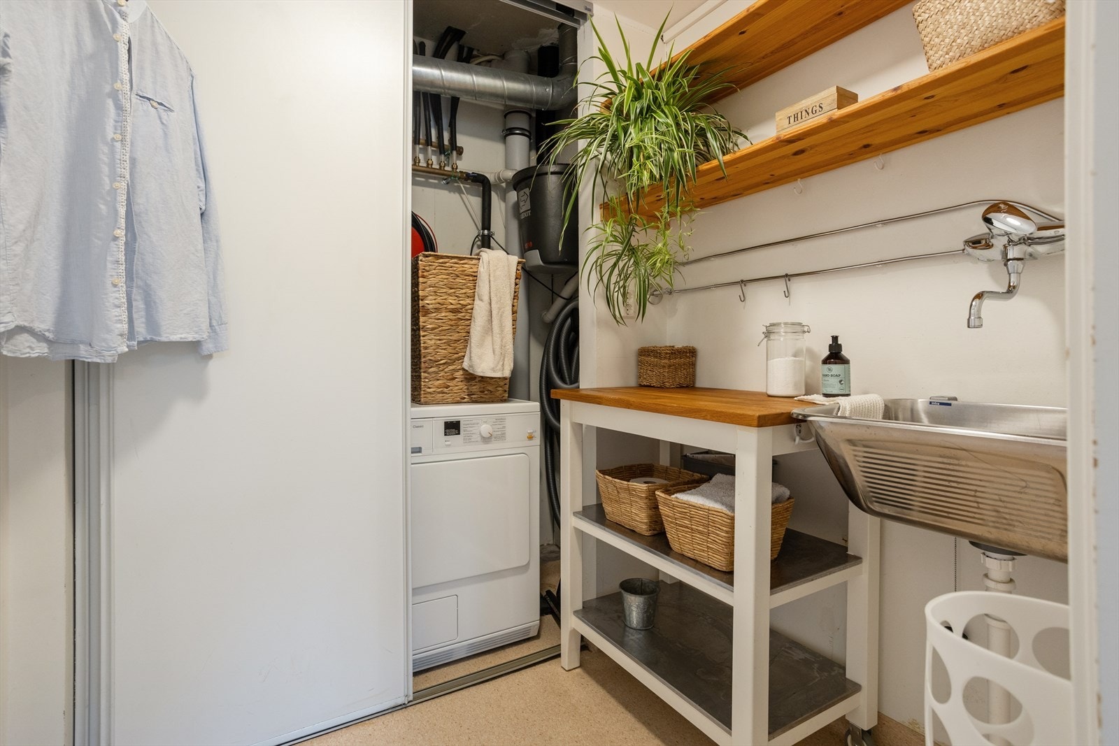 Praktisk vaskerom med brettebenk og smarte løsninger som skjuler tekniske installasjoner og sentralstøvsuger. Galleribilde