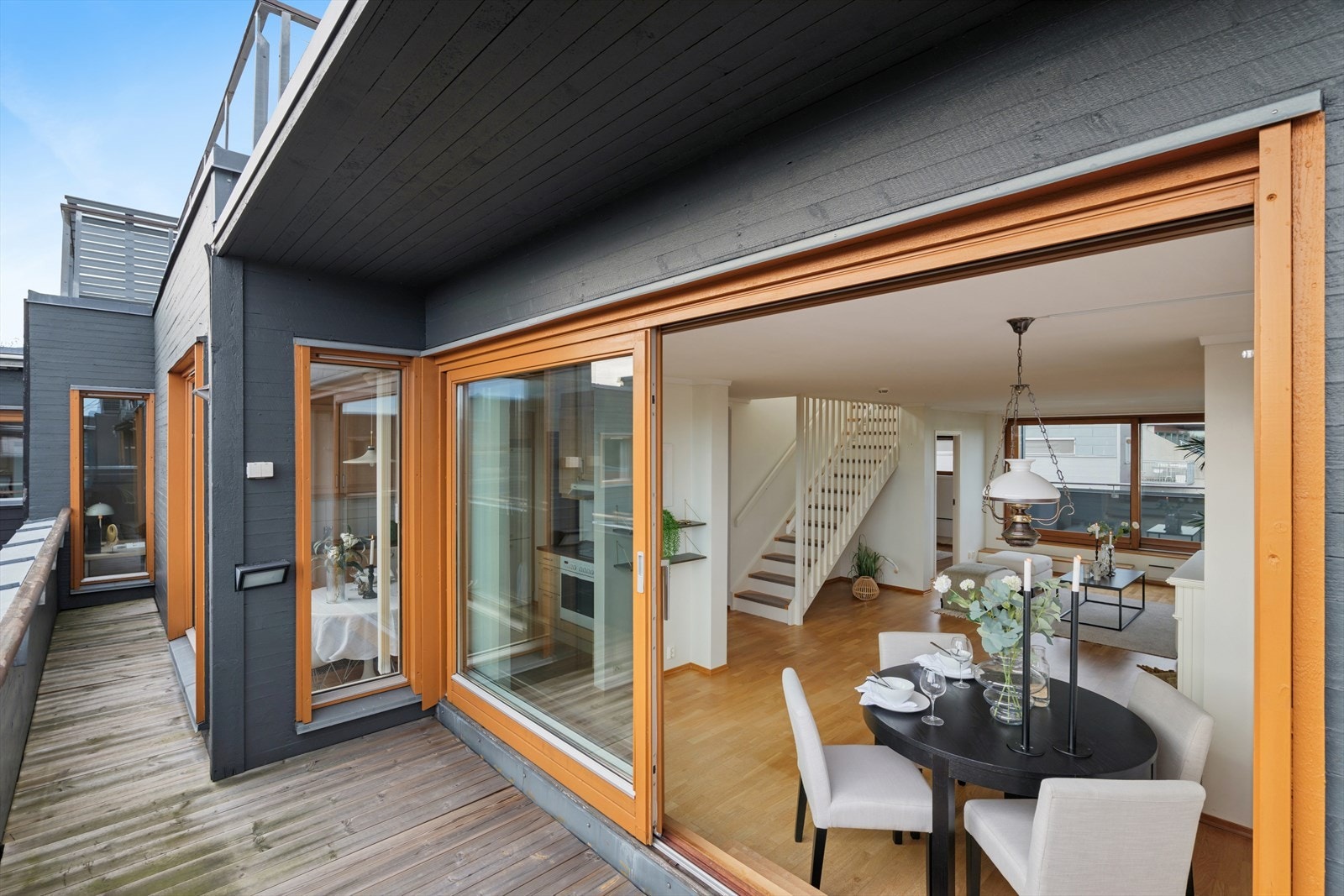 Store skyvedører ut til delvis overbygget balkong på hver side av stuen. Galleribilde
