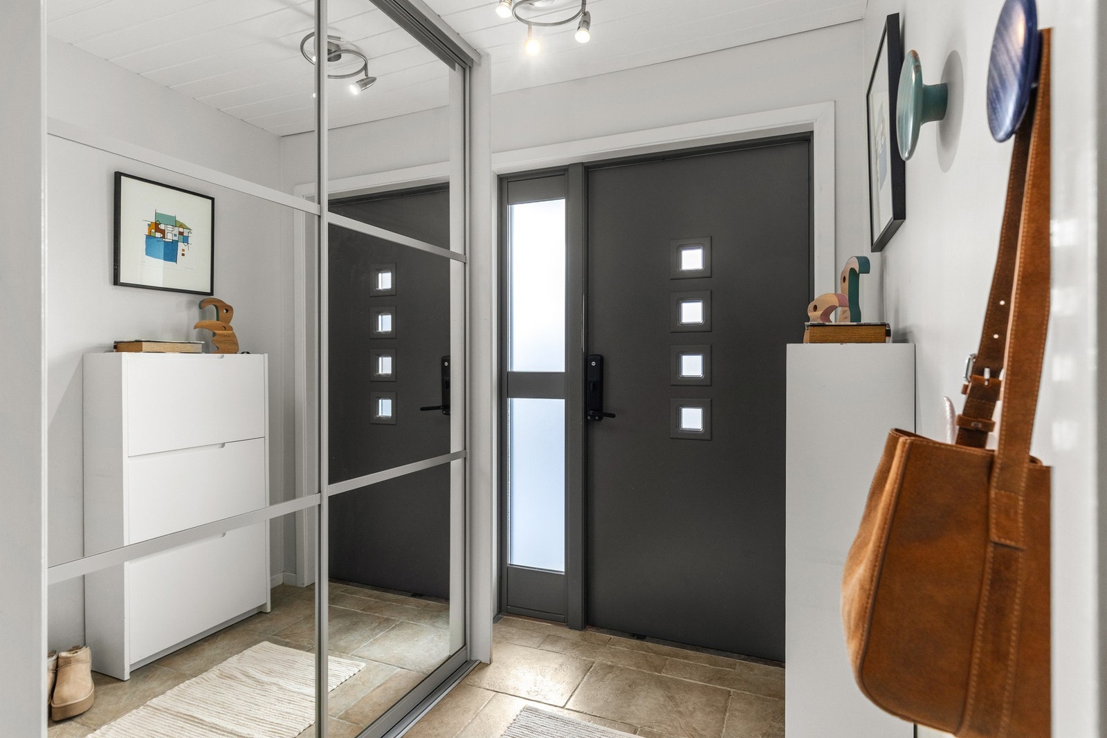 Innbydende entré med god plass til sko og yttertøy i en stor skyvedørsgarderobe. Galleribilde