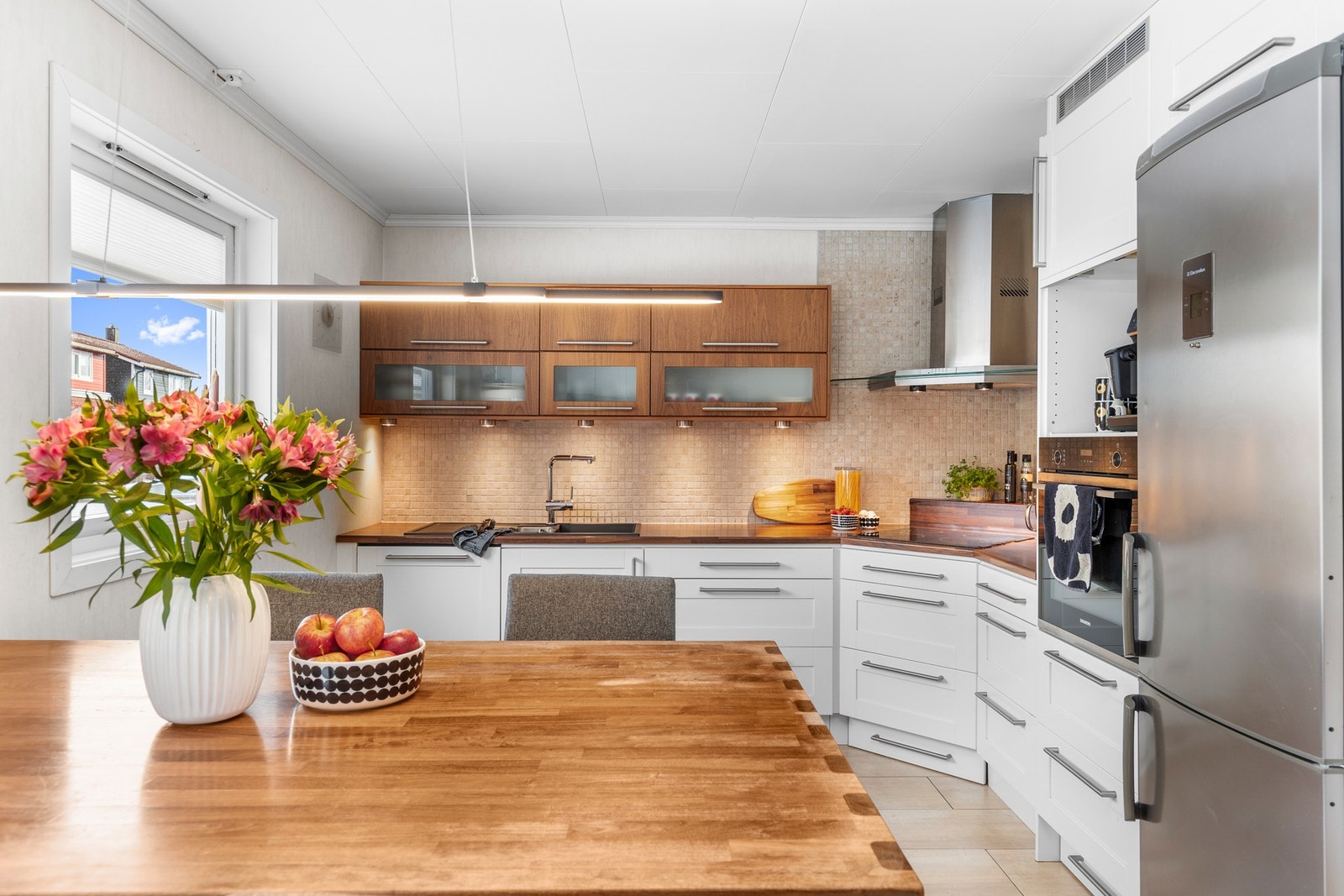 Romslig kjøkken med funksjonell utforming, gode arbeidsflater og flislagt gulv med varmekabler. Galleribilde