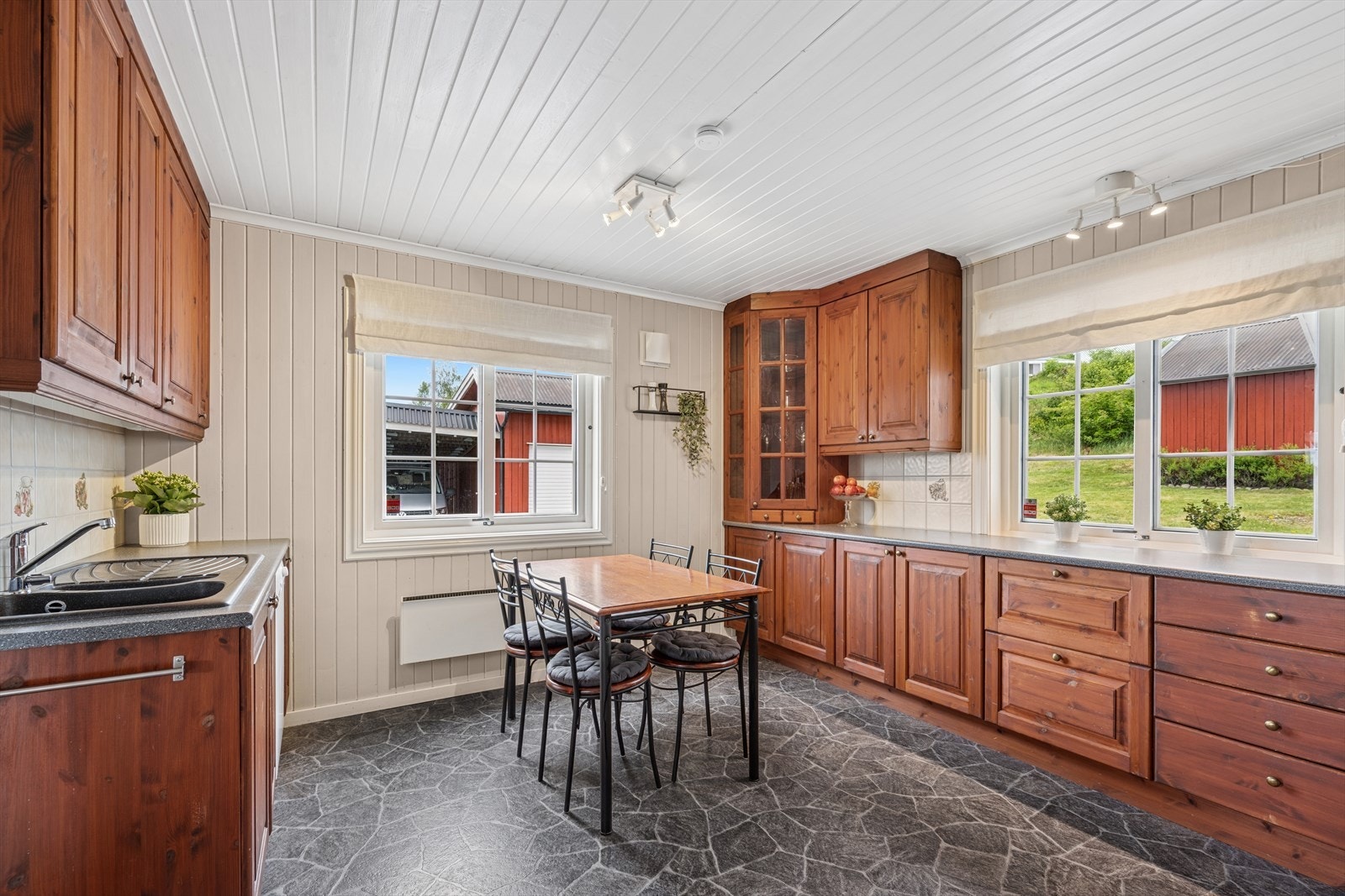 Romslig kjøkkeninnredning med heltre skrog og laminert benkeplate. Galleribilde