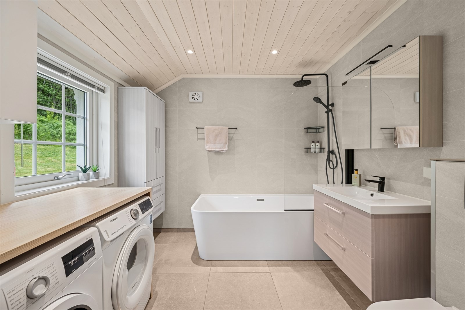 Badekar med veggmontert dusjbatteri. Opplegg for vaskemaskin. Elektrisk baderomsvifte. Galleribilde