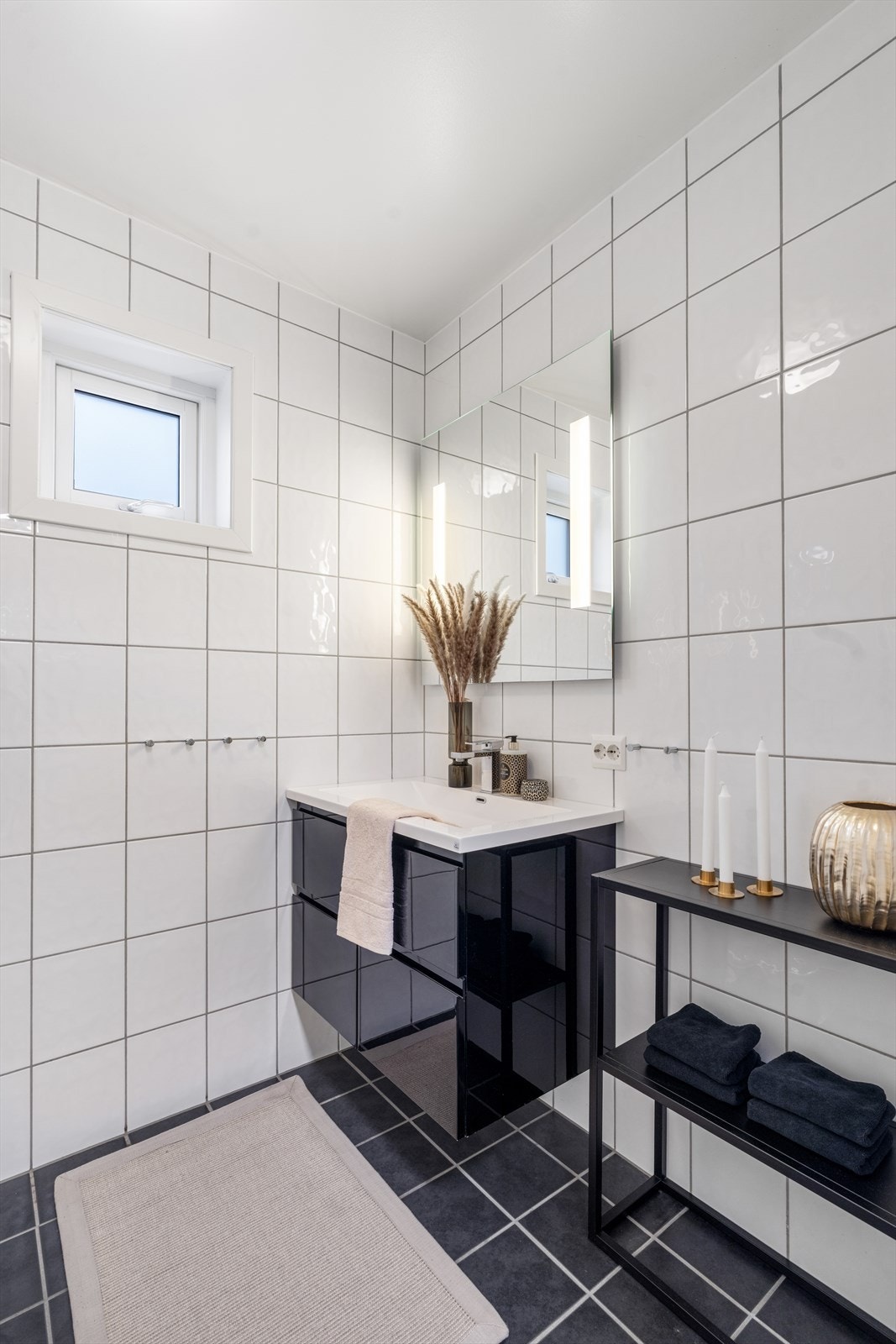 Badet har stilren innredning og speil med integrert belysning. Galleribilde