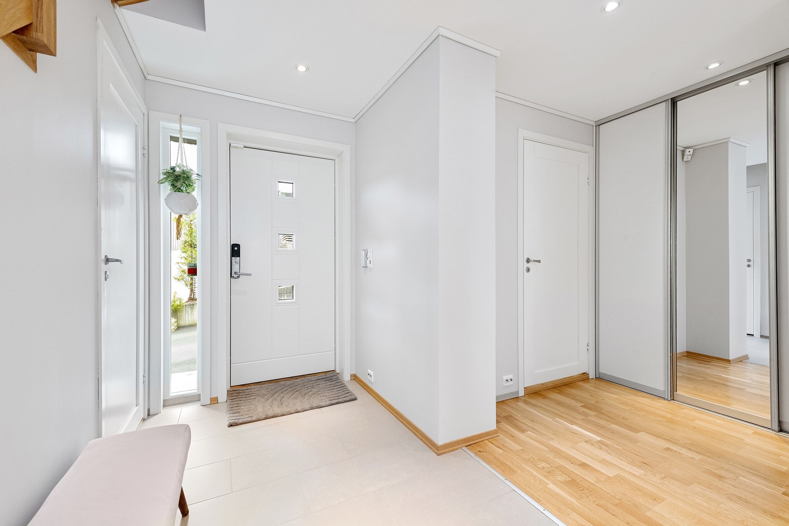 Inngangspartiet har dels flislagt gulv med varmekabler og dels parkett, hvite profilerte innerdører og en romslig skyvedørsgarderobe med dels speilfront Galleribilde