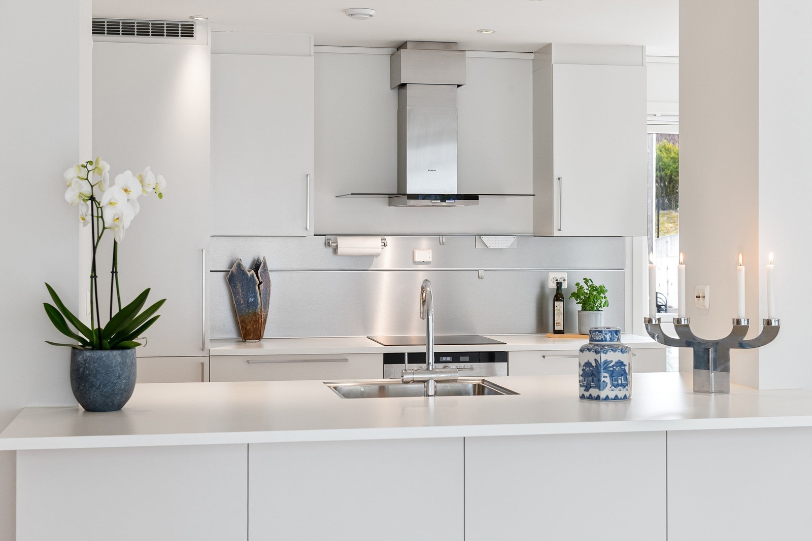 Kjøkkenøya har nedfelt servant og rikelig med benkeplass. Innredningen har glatte hvite fronter Galleribilde