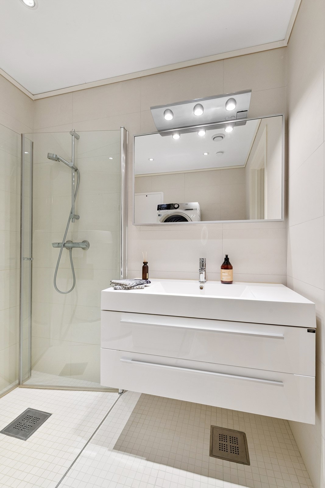 Flott innredning på bad i 1 etg. med en heldekkende servant med god oppbevaring i skuffer og speil med belysning Galleribilde