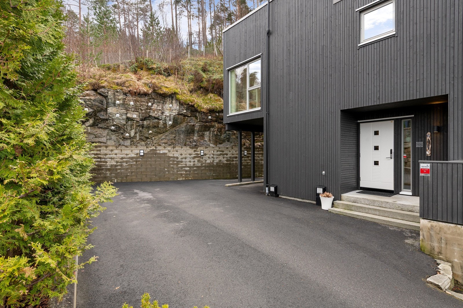 Asfaltert gårdsplass med gode parkeringsmuligheter, inkludert en carport med mulighet for elbillader Galleribilde