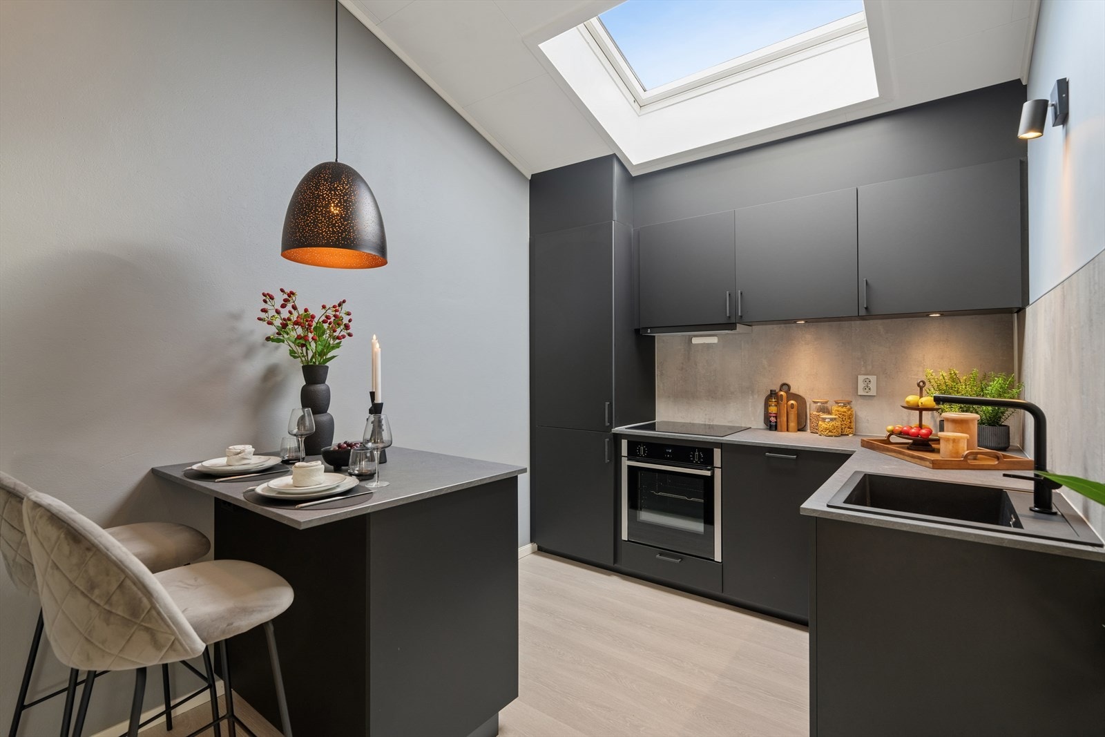 Kjøkkenet er nytt fra 2021, med integrerte hvitevarer og stilrene, sorte fronter. Takvinduet gir rikelig med dagslys. Galleribilde