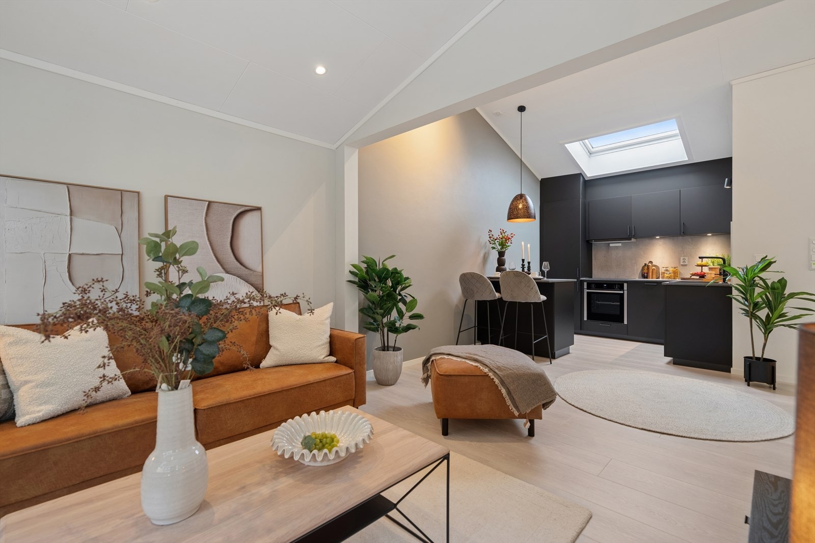 Den åpne løsningen skaper en sosial sone der stue og kjøkken flyter sømløst sammen. Galleribilde