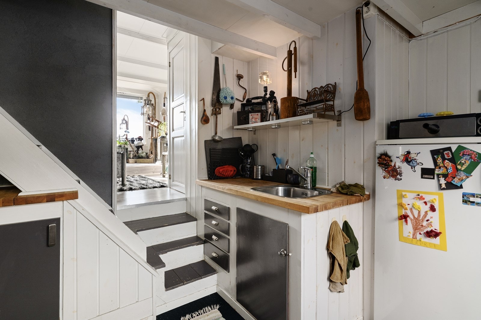 Heltre benkeplate med god arbeidsflate og nedfelt oppvaskkum i rustfritt stål. Det er avsatt plass til frittstående kjøleskap og komfyr. Over kokesonen er det montert ventilator. Galleribilde