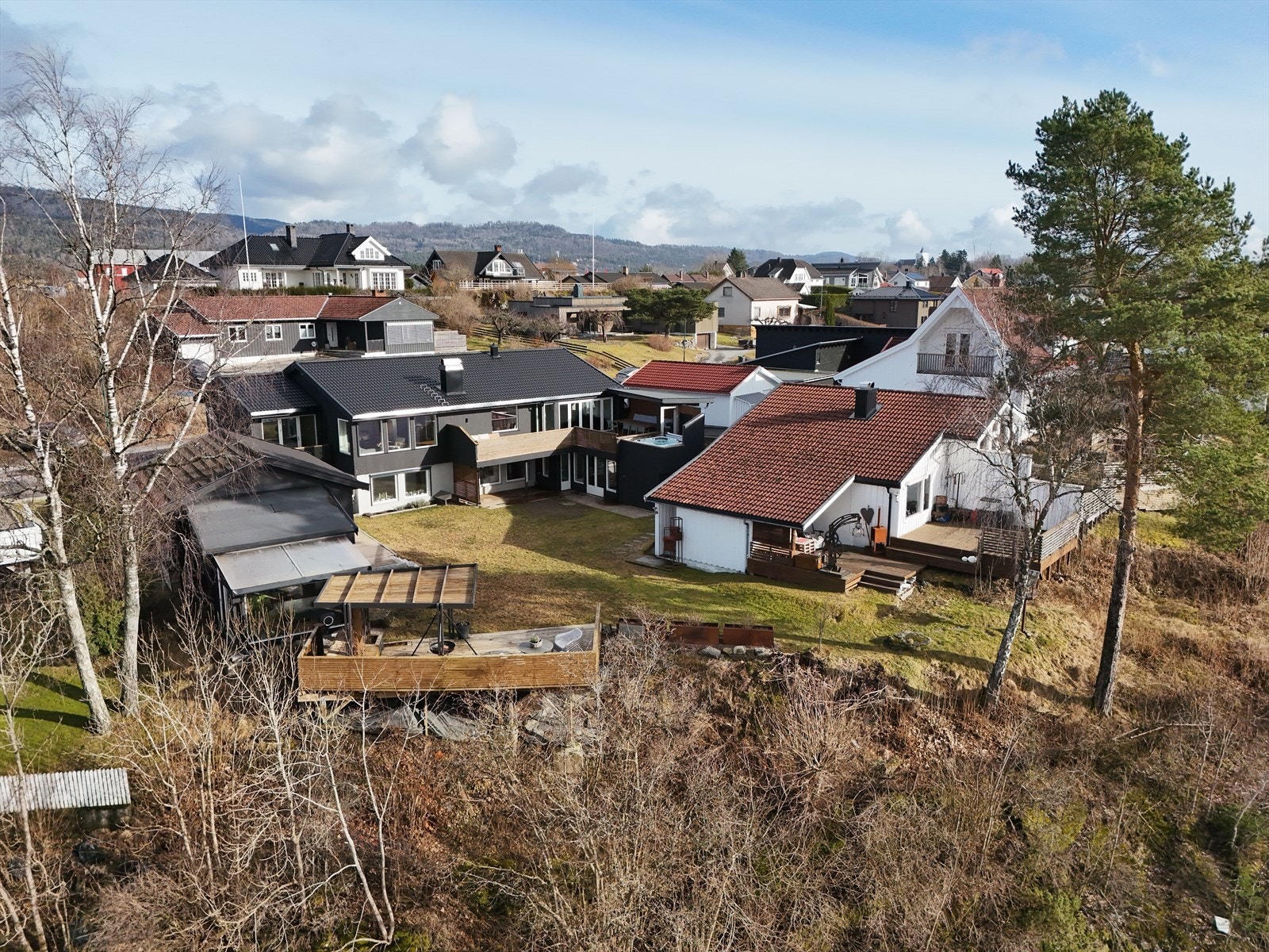 Stor og solrik tomt, pent opparbeidet med asfaltert gårdsplass, beplantet hageområde og flere nydelige uteplasser. Terrasser og hage ligger skjermet til uten innsyn Galleribilde