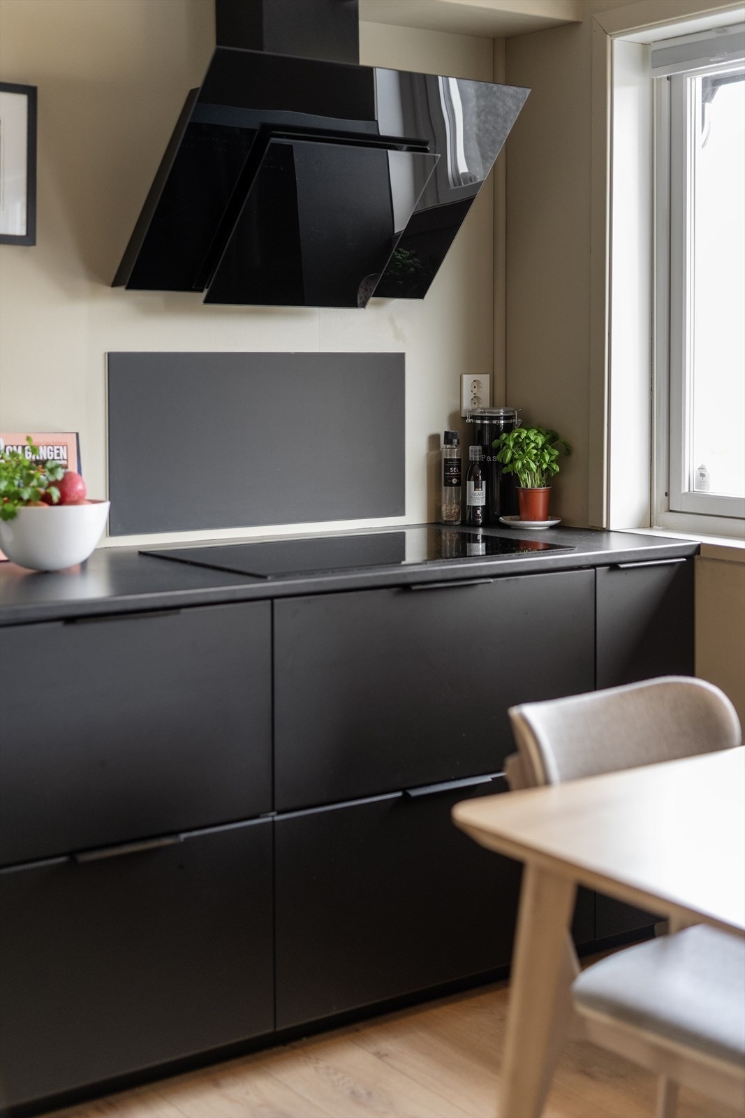 Laminat benkeplate i mørk utførelse, med nedfelt platetopp og oppvaskkum i rustfritt stål. Ett-greps blandebatteri med Quooker, som gir deg kokende vann på et øyeblikk. Galleribilde