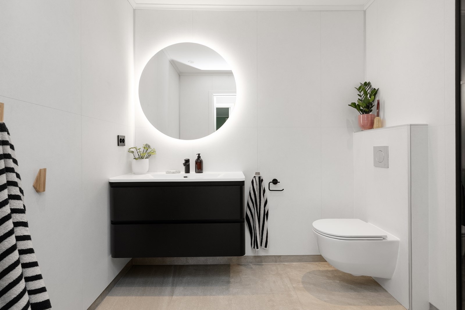 Lyst og pent bad i hovedetasjen, pusset opp av fagfolk i 2020. Badet har flislagt gulv med varmekabler, veggmontert toalett og pen servantinnredning, samt speil med belysning. Galleribilde