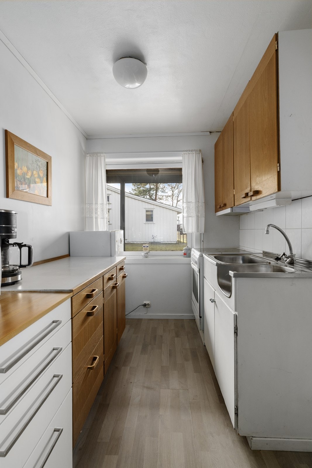 Kjøkkenet har innredning av eldre dato, med profilerte trefronter og laminat benkeplate, samt benkebeslag i rustfritt stål. Det er avsatt plass til frittstående kjøleskap og komfyr. Galleribilde