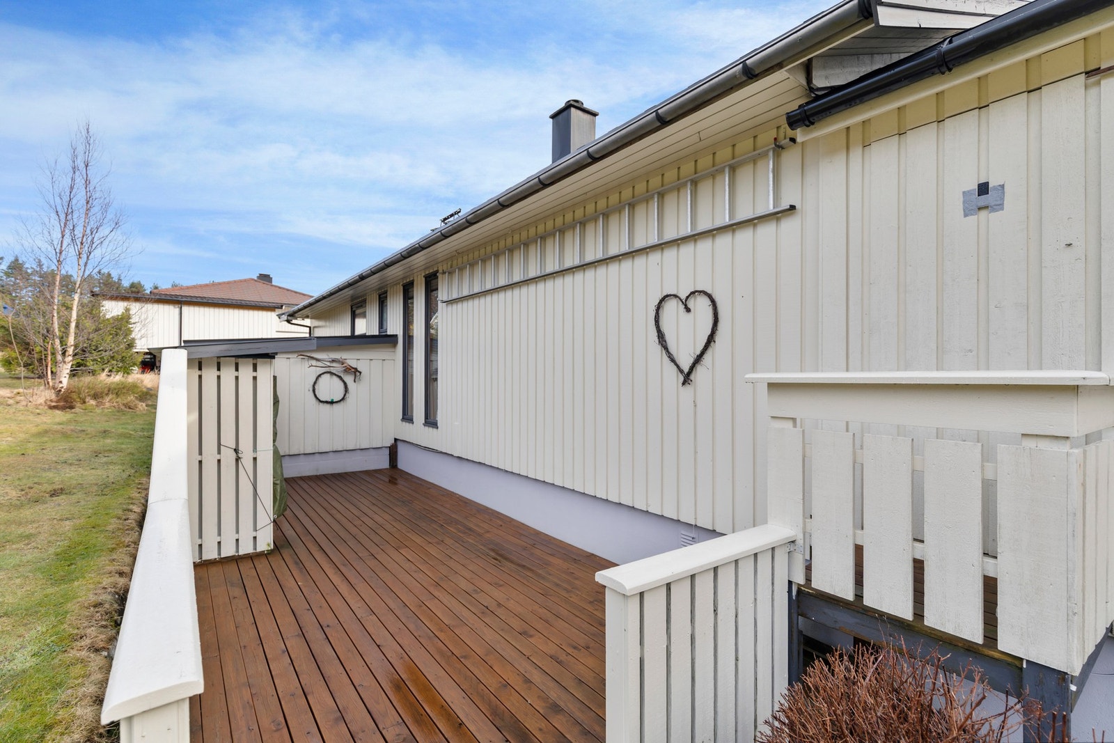 Fra terrasse fører trapp i trekonstruksjon ned til terrasse på baksiden av boligen. Galleribilde