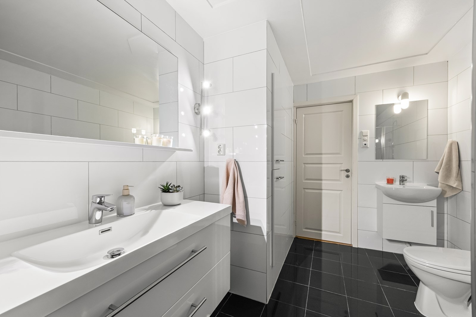 Innredningen består av to servanter med underskap, toalett og dusjhjørne med glassvegger. Galleribilde