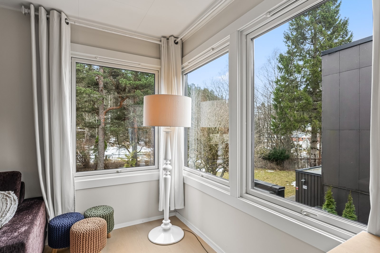 Vindusflatene i stuen slipper inn dagslys og gir utsyn mot grønne omgivelser. Galleribilde