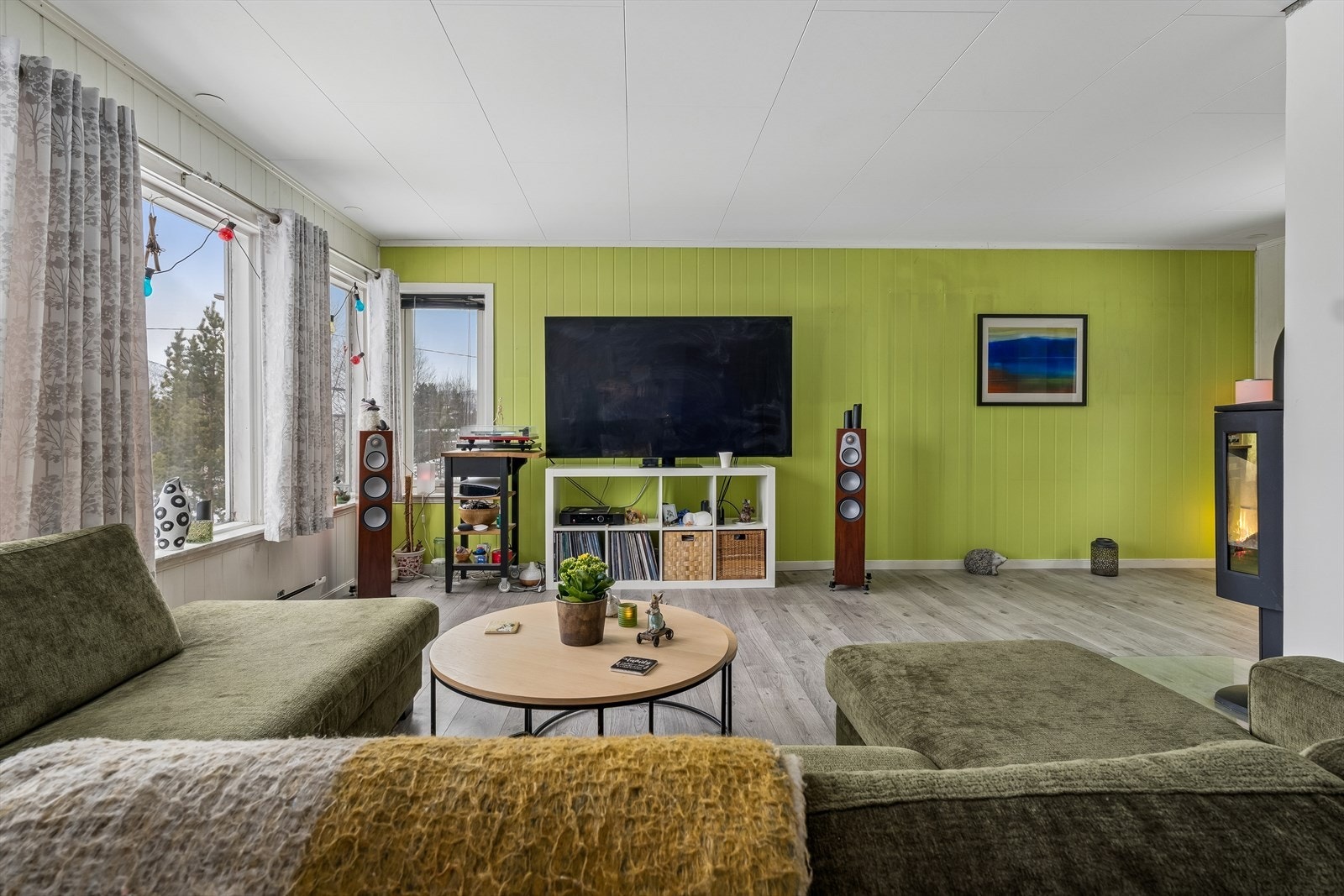 Stuen har laminatgulv og vegger med malt trepanel og malte slette overflater. Galleribilde